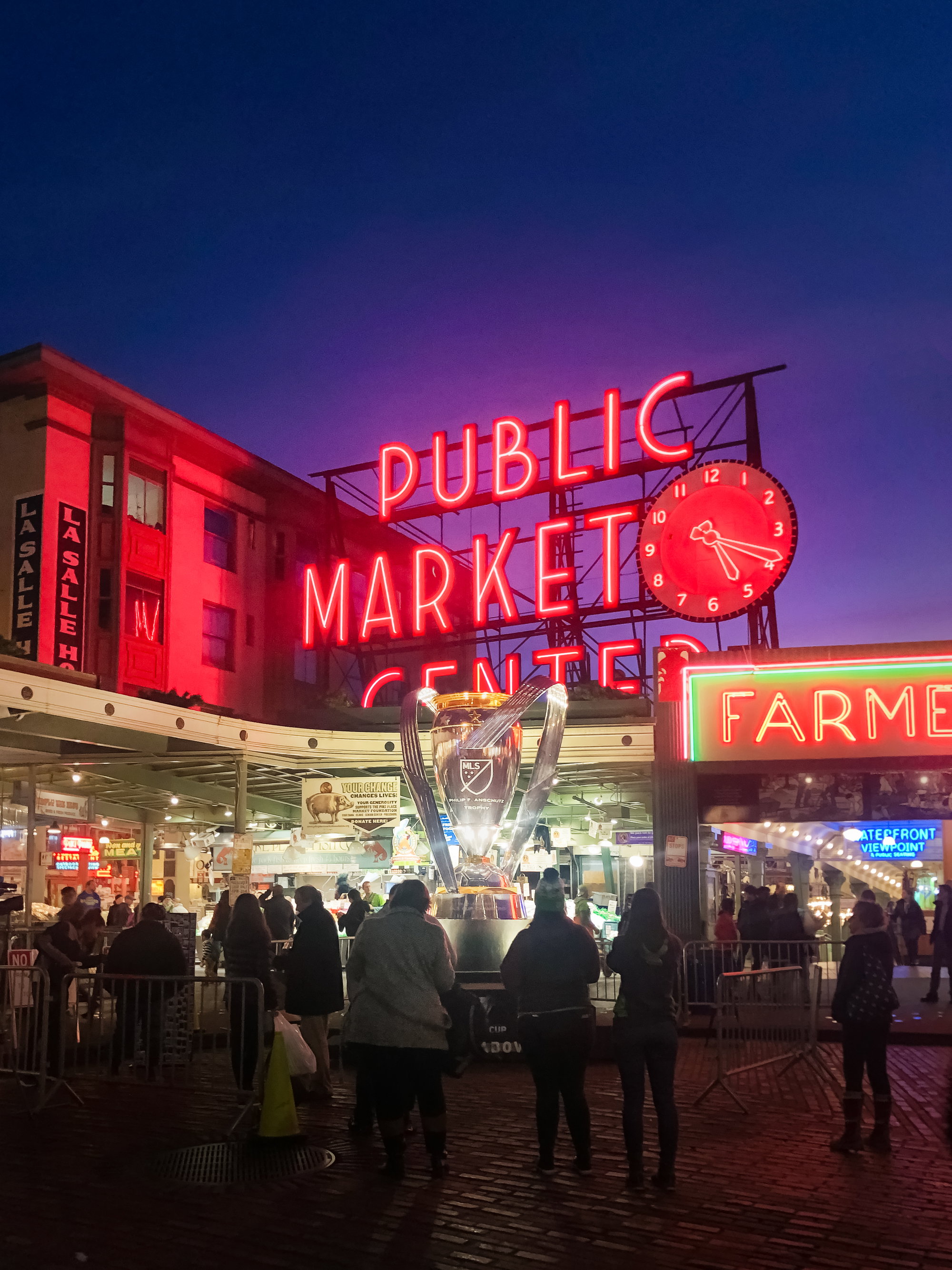 Under a twilight sky, the MLS Cup glows outside Pike Place Market.