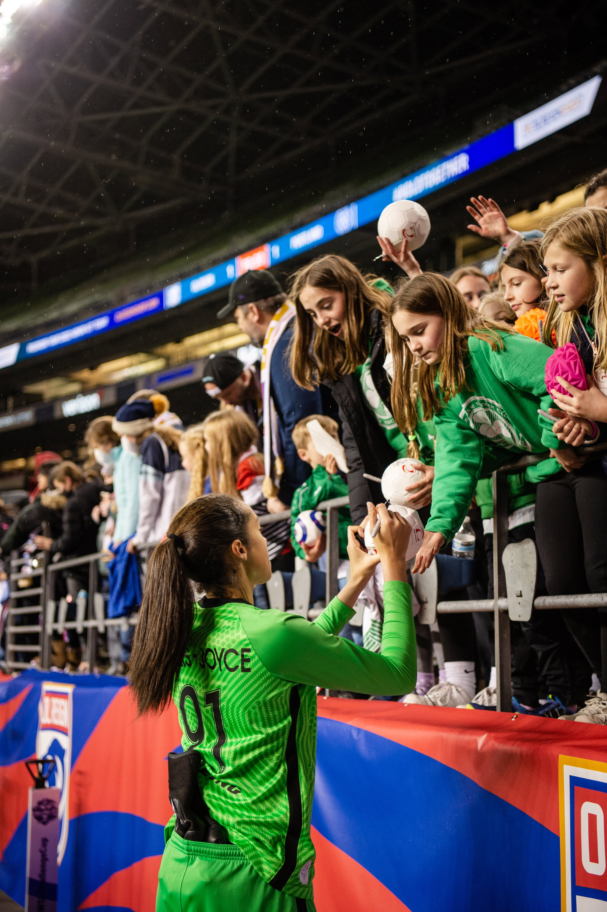 An OL Reign player signing autographs at the stadium.
